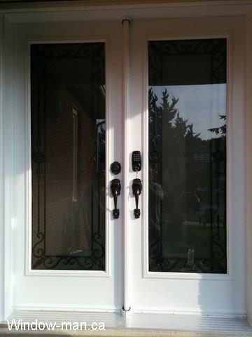 Double front door. White entry steel insulated. Full wrought iron glass inserts. Custom iron glass design